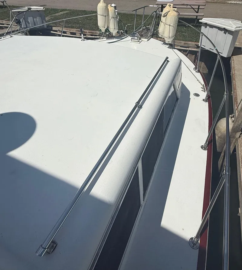 Slide: The Image of 1985 Marinette 32 Sedan boat docked, showing deck and railing details. - 5