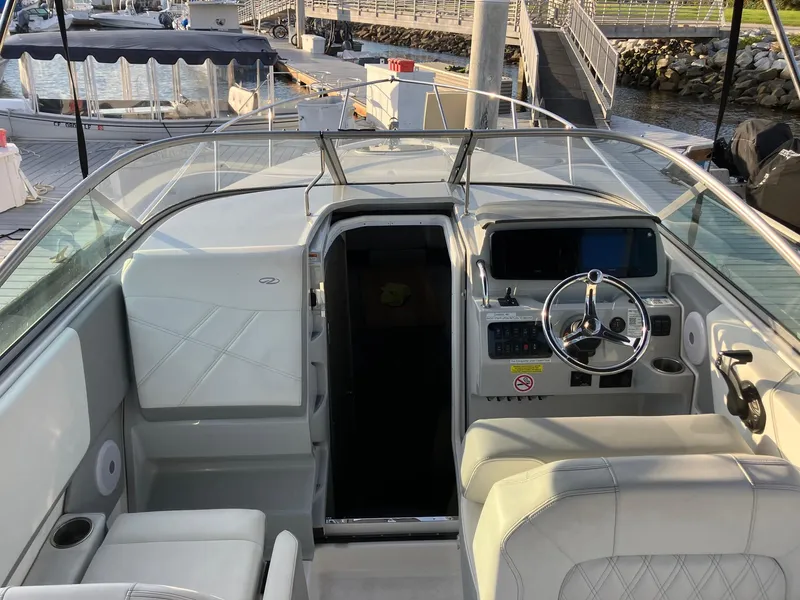 Slide: The Image of 2023 Regal 26 XO boat interior with helm, seating, and dock view. - 12