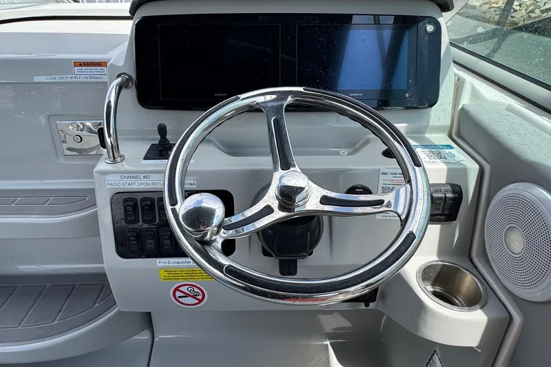 Slide: The Image of 2023 Regal 26 XO boat helm with steering wheel and control panel. - 13