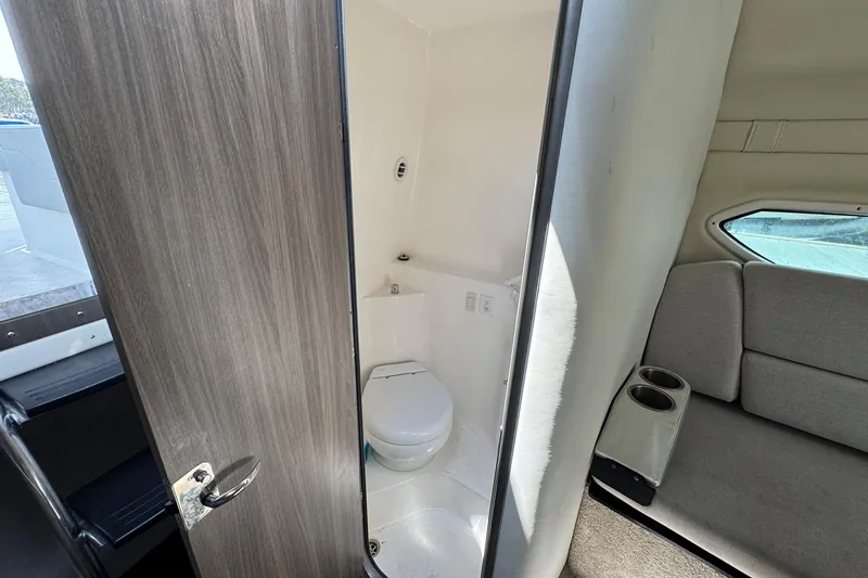 Slide: The Image of 2023 Regal 26 XO boat interior with compact bathroom and seating area. - 19