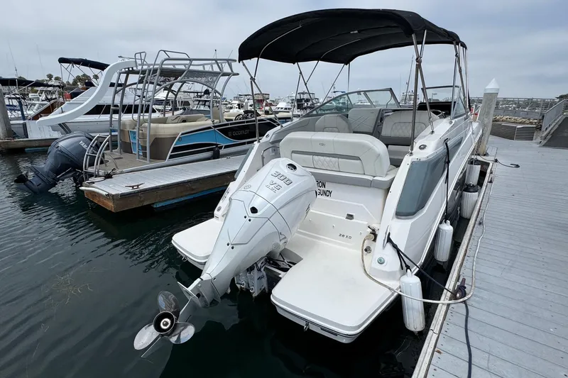 Slide: The Image of 2023 Regal 26 XO boat docked, featuring a powerful outboard motor and spacious seating. - 3