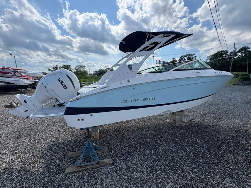 Slide: The Image of 2025 Regal LX4 boat with Yamaha engine, displayed outdoors under a cloudy sky. - 2