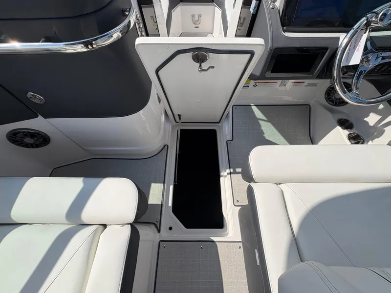 Slide: The Image of 2025 Regal LX4 boat interior with open storage compartment and white seating. - 21