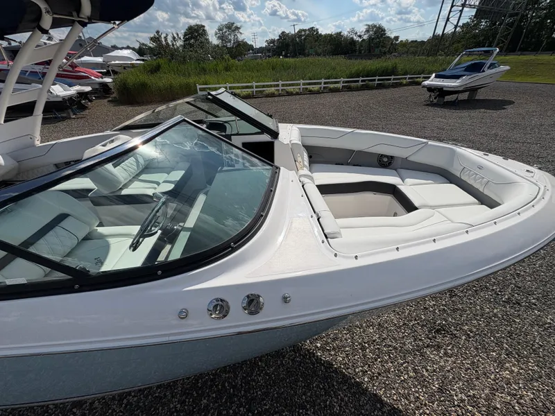 Slide: The Image of 2025 Regal LX4 boat with sleek design and spacious seating, parked outdoors. - 6