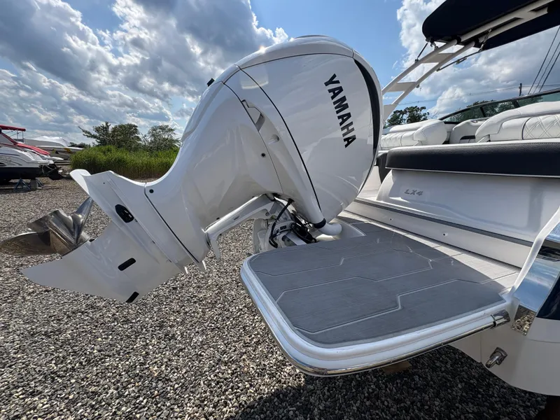 Slide: The Image of 2025 Regal LX4 boat with Yamaha outboard motor on gravel lot under cloudy sky. - 8