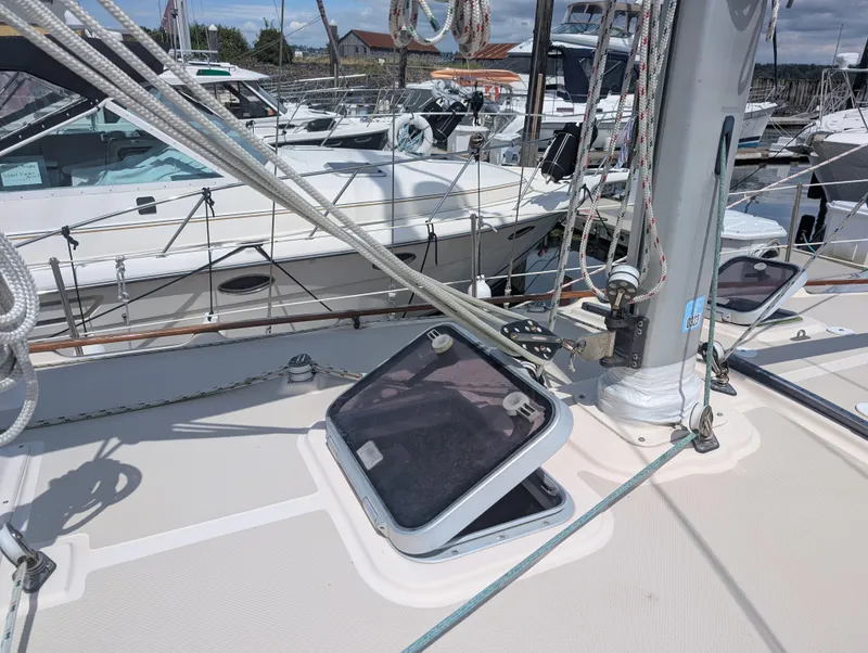 Slide: The Image of Sailboat deck of 1994 Island Packet 35 with open hatch and rigging in marina. - 10