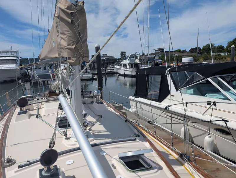 Slide: The Image of 1994 Island Packet 35 sailboat docked in a marina, surrounded by other boats. - 14