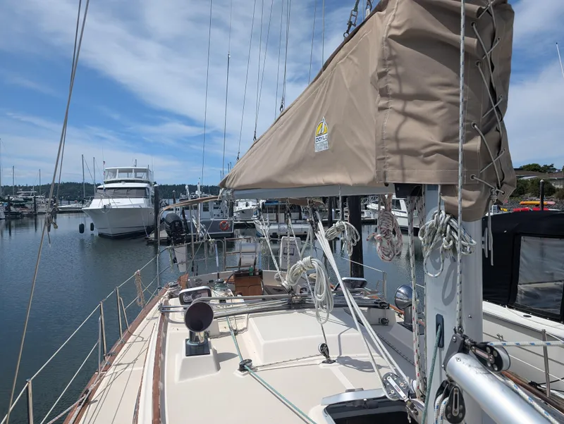 Slide: The Image of 1994 Island Packet 35 sailboat docked at marina under clear blue sky. - 16