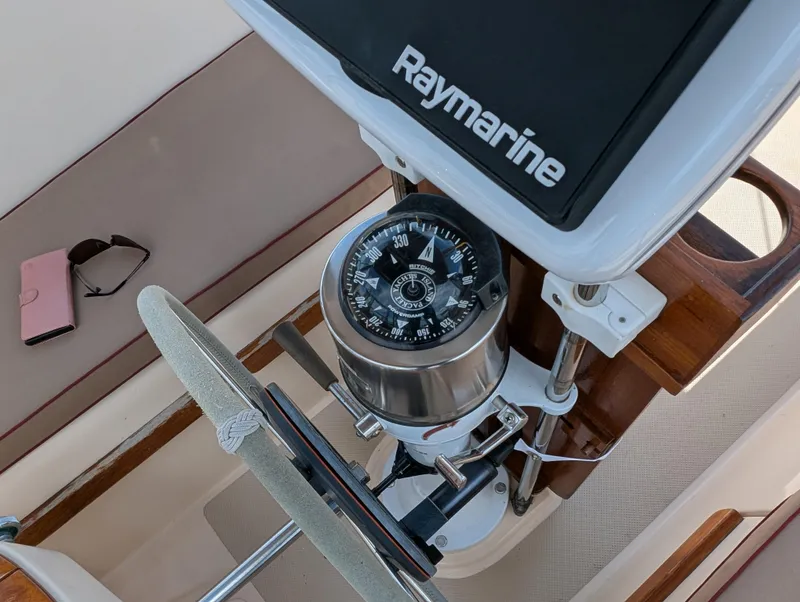 Slide: The Image of 1994 Island Packet 35 sailboat cockpit with Raymarine compass and steering wheel. - 22