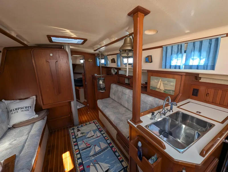 Slide: The Image of Interior of 1994 Island Packet 35 sailboat with cozy seating and kitchenette. - 26
