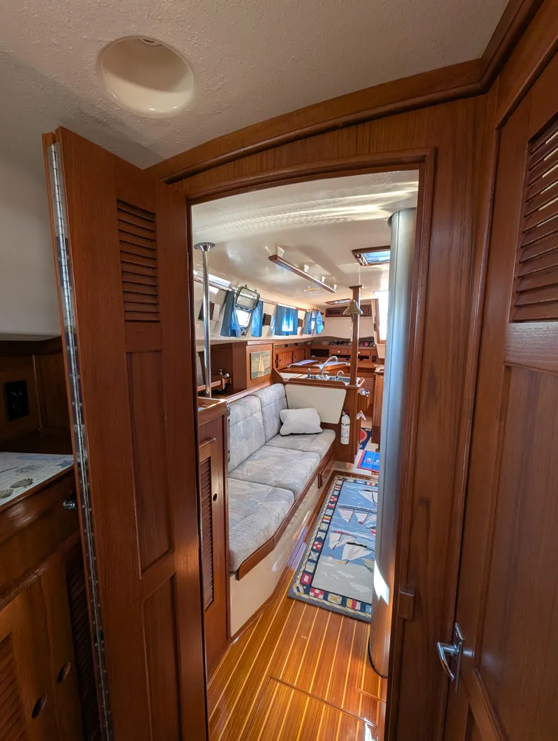 Slide: The Image of Interior of 1994 Island Packet 35 sailboat, featuring cozy seating and wooden finishes. - 27
