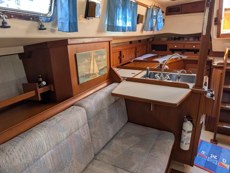 Slide: The Image of Interior of 1994 Island Packet 35 sailboat with cozy seating and kitchen area. - 30