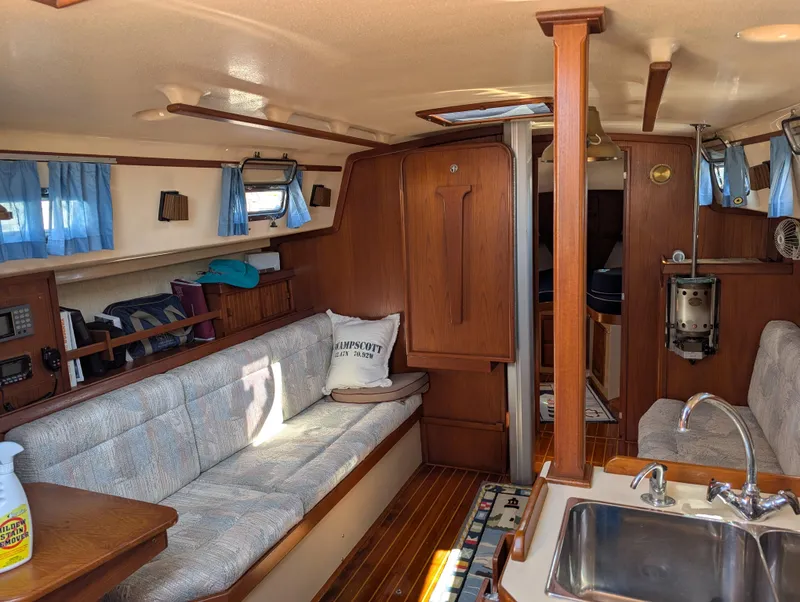 Slide: The Image of Interior of a 1994 Island Packet 35 sailboat with cozy seating and wooden finishes. - 32