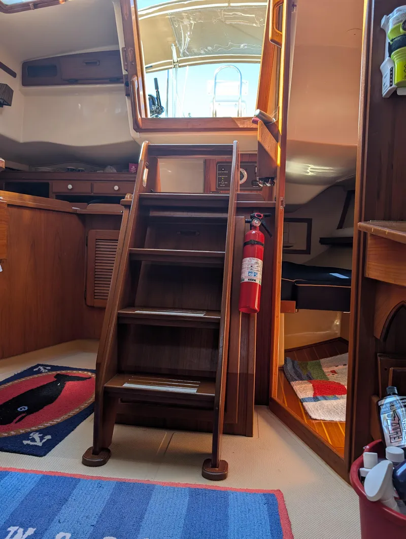 Slide: The Image of Interior of 1994 Island Packet 35 sailboat with wooden stairs and fire extinguisher. - 42