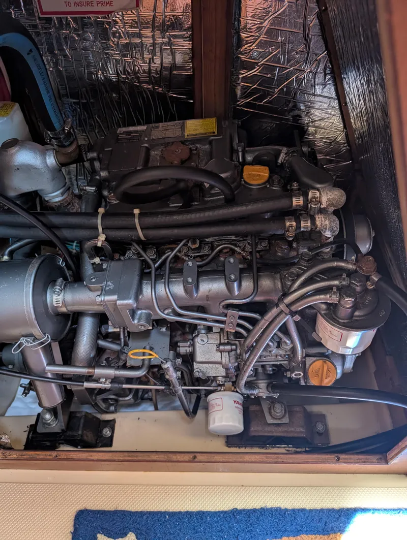 Slide: The Image of Engine compartment of a 1994 Island Packet 35 sailboat, showcasing mechanical components and wiring. - 47