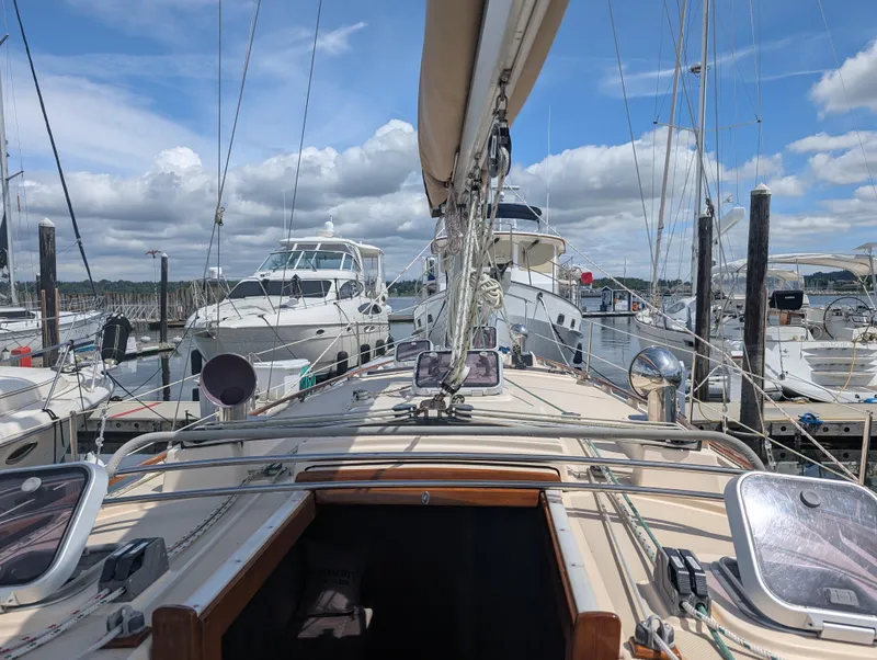Slide: The Image of 1994 Island Packet 35 sailboat docked at marina under blue sky. - 6