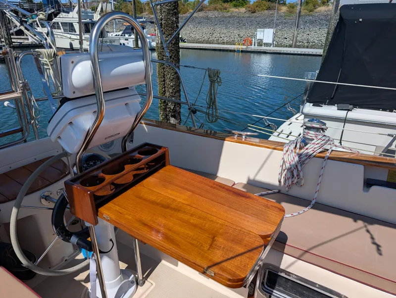 Slide: The Image of Cockpit of 1994 Island Packet 35 sailboat with wooden table and steering wheel. - 9