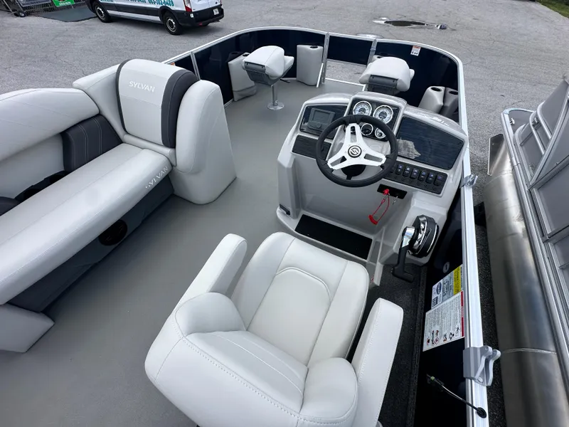Slide: The Image of 2026 Sylvan Mirage Fish 820 Party Fish 4.0 interior with helm and seating. - 4