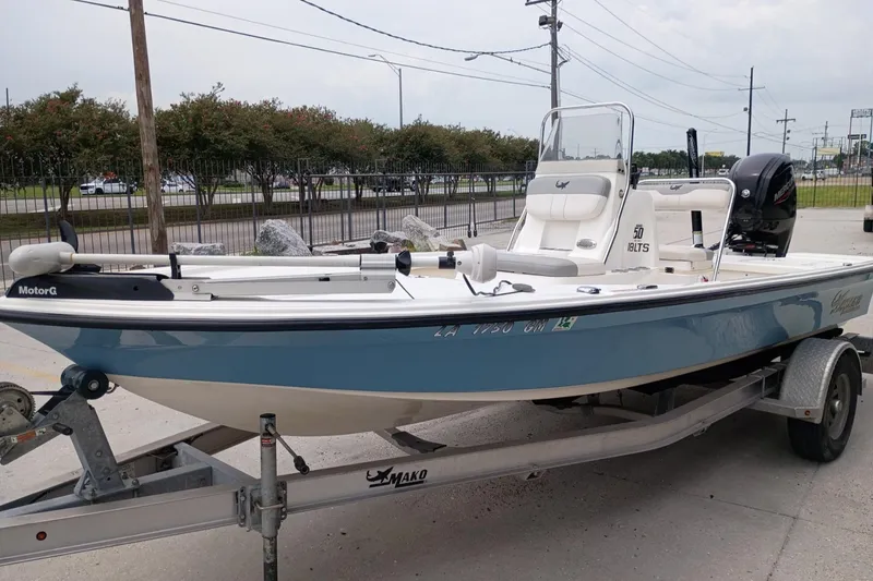 Slide: The Image of 2018 Mako 18 LTS boat on trailer, blue and white, parked outdoors. - 6