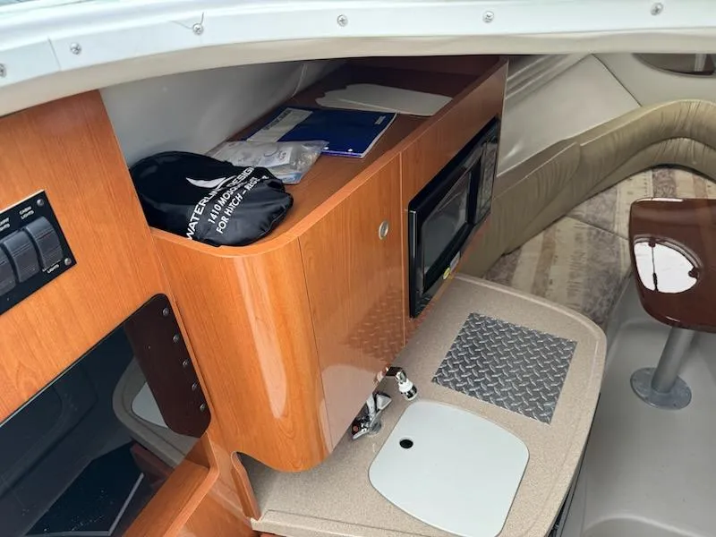 Slide: The Image of 2001 Four Winns 248 Vista cabin interior with wood cabinetry and compact kitchen area. - 16