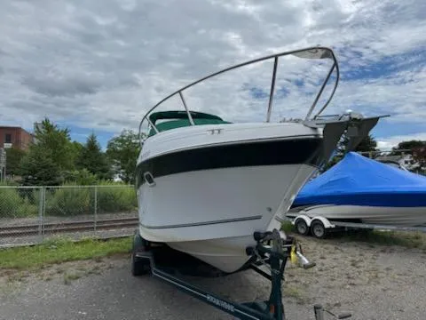 Slide: The Image of 2001 Four Winns 248 Vista boat on trailer, parked outdoors under cloudy sky. - 9