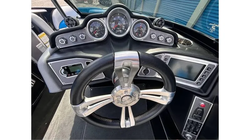 Slide: The Image of 2017 MasterCraft X23 boat dashboard with steering wheel and control gauges. - 11