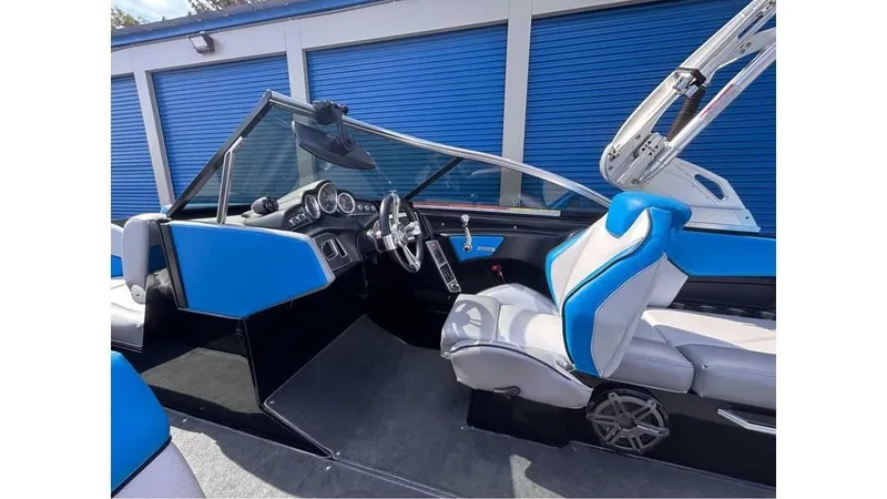Slide: The Image of 2017 MasterCraft X23 boat interior with blue and white seating, sleek dashboard, and modern design. - 13