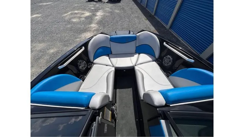 Slide: The Image of 2017 MasterCraft X23 boat interior with blue and white seating, outdoor storage background. - 16