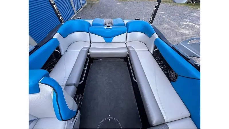 Slide: The Image of 2017 MasterCraft X23 interior with blue and gray seating, spacious layout, and cup holders. - 20