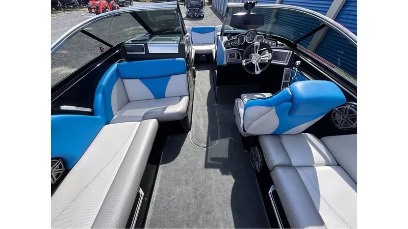 Slide: The Image of 2017 MasterCraft X23 boat interior with blue and gray seating, modern dashboard, and steering wheel. - 24