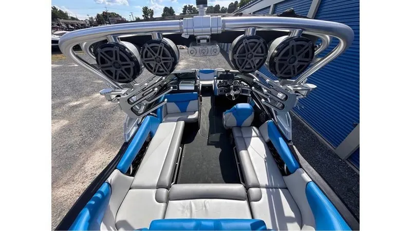 Slide: The Image of 2017 MasterCraft X23 boat interior with blue and gray seating, advanced sound system, and sleek design. - 25
