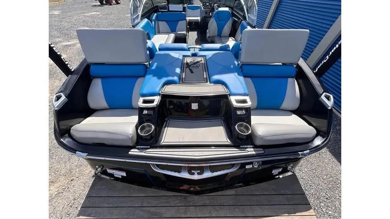 Slide: The Image of 2017 MasterCraft X23 boat interior with blue and gray seating, cup holders, and storage compartments. - 28