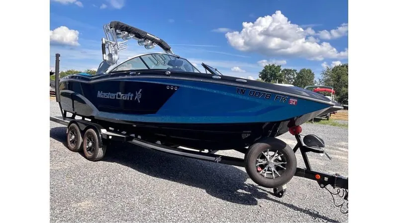 Slide: The Image of 2017 MasterCraft X23 boat on trailer under blue sky. - 4