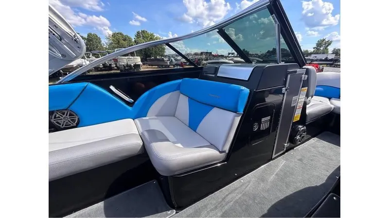 Slide: The Image of 2017 MasterCraft X23 boat interior with blue and white seating, under a clear sky. - 8