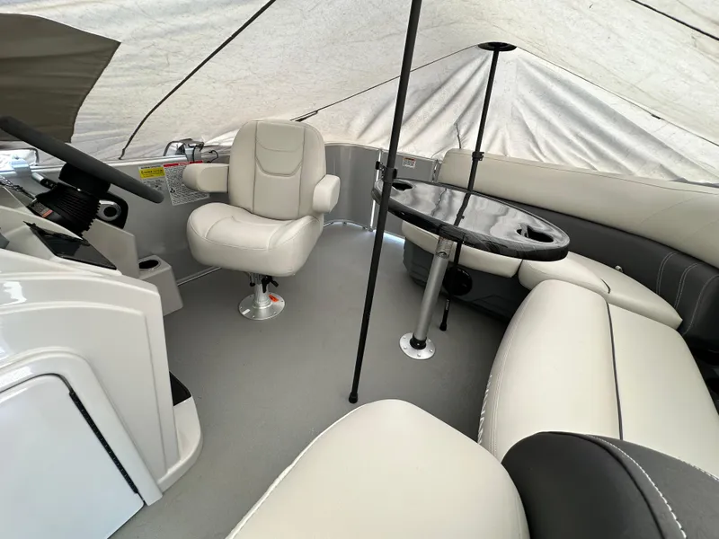 Slide: The Image of 2025 Sylvan Mirage 818 Cruise interior with white seating and a central table under a canopy. - 18