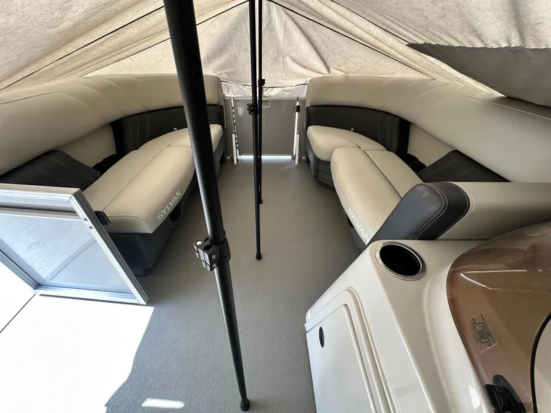 Slide: The Image of 2025 Sylvan Mirage 818 Cruise interior with beige seating under a canopy. - 19