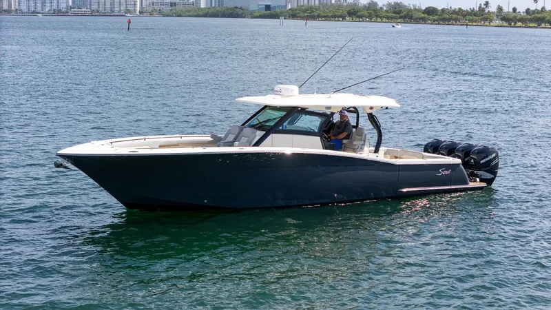 The Image of 2020 Scout 380 LXF boat on water with city skyline in background. - 0