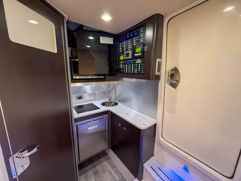 Slide: The Image of 2020 Scout 380 LXF boat interior with kitchenette, control panel, and modern amenities. - 27