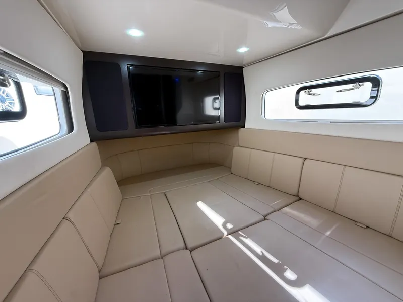 Slide: The Image of Luxurious interior of 2020 Scout 380 LXF boat with beige seating and a flat-screen TV. - 42