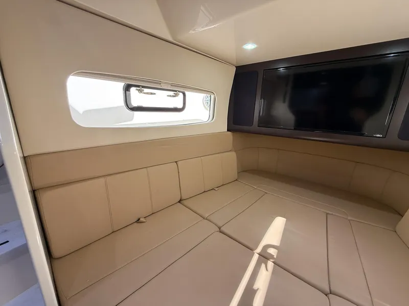 Slide: The Image of Luxurious interior of 2020 Scout 380 LXF boat with beige seating and mounted TV. - 44