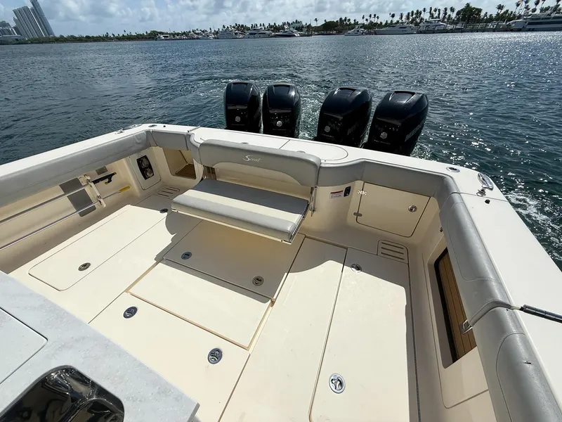 Slide: The Image of 2020 Scout 380 LXF boat deck with seating and four outboard engines on the water. - 47