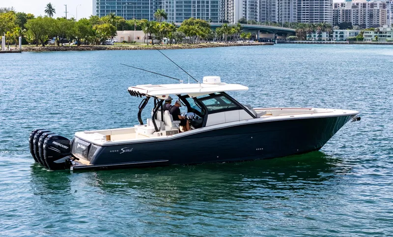 Slide: The Image of 2020 Scout 380 LXF boat cruising on water with cityscape background. - 5