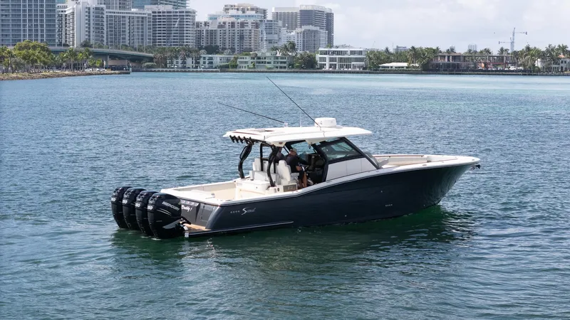 Slide: The Image of 2020 Scout 380 LXF boat cruising near city skyline. - 6