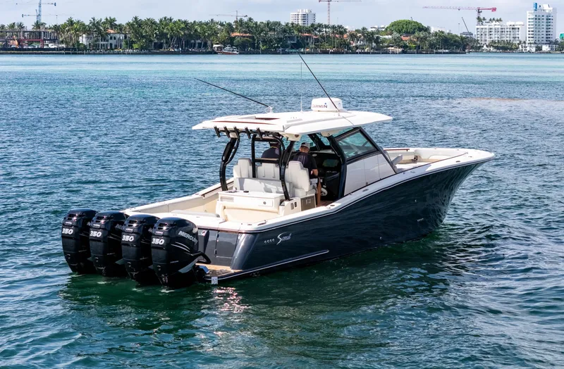 Slide: The Image of 2020 Scout 380 LXF boat with four engines cruising on clear blue water. - 7