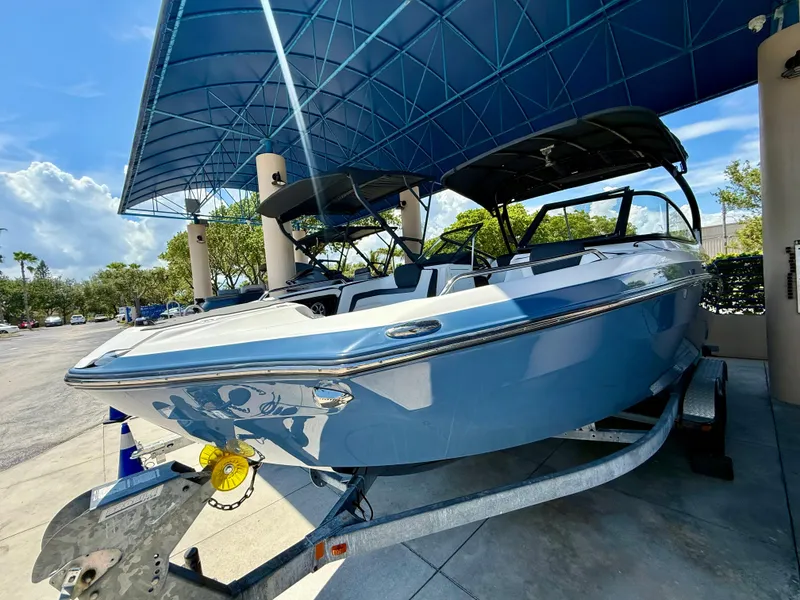 Slide: The Image of 2018 Yamaha Boats 242 Limited S E-Series under blue canopy on trailer. - 2