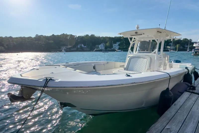 Slide: The Image of 2022 Sea Fox 288 Commander boat docked on a sunny day, with scenic waterfront background. - 10