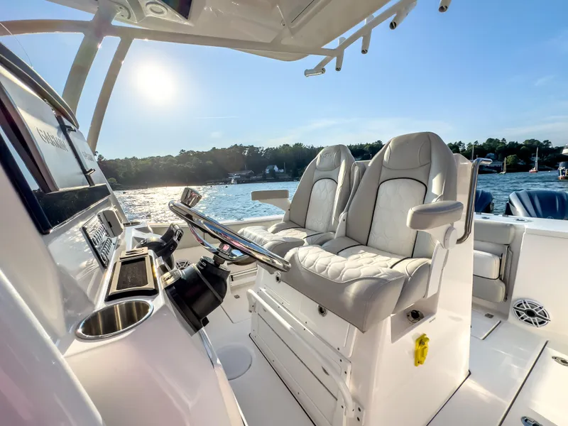 Slide: The Image of 2022 Sea Fox 288 Commander boat interior with luxurious seating and steering wheel, on a sunny day. - 29