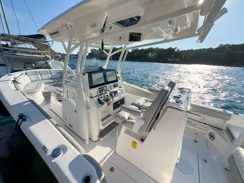 Slide: The Image of 2022 Sea Fox 288 Commander boat interior with modern helm and seating, docked by the water. - 3