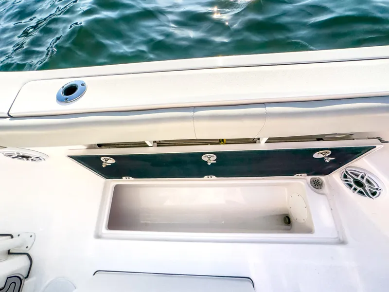 Slide: The Image of 2022 Sea Fox 288 Commander boat storage compartment with open hatch, near water. - 33