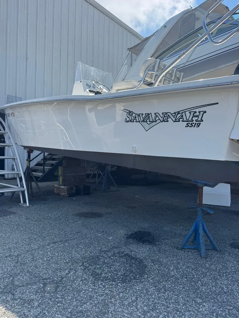 The Image of Savannah SS19 boat, 2021 model, with Mercury engine, docked beside a larger vessel. - 0